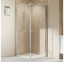 Douche d''angle avec porte battante et robinetterie de douche devant un mur à motifs
