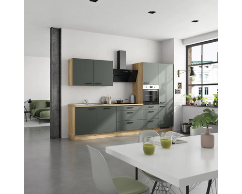 Cuisine moderne verte avec éléments en bois et table à manger dans une pièce lumineuse