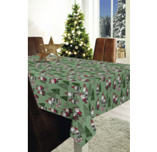 Table avec une nappe de Noël avec des nains et des sapins dans une pièce décorée.