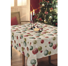 Tisch mit Weihnachtstischdecke, Dekoration und Weihnachtsbaum im Hintergrund