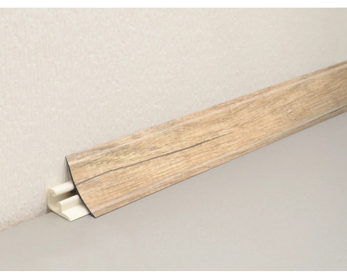 Plinthe avec décor bois et fixation par clip sur un mur