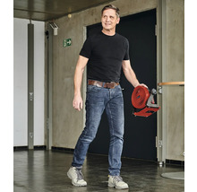 Un homme transporte un ventilateur sans fil dans un couloir