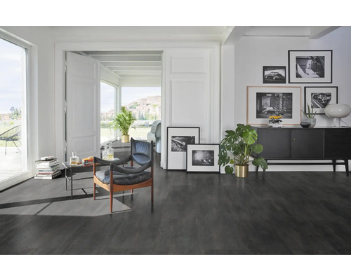 Modernes Wohnzimmer mit dunklem Bodenbelag, Sesseln und dekorativen Elementen