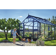 Gewächshaus mit Glaswänden und einer Person, die sich darin aufhält, sowie einem Mädchen und Hühnern im Garten.