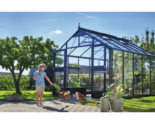 Gewächshaus mit Glaswänden und einer Person, die sich darin aufhält, sowie einem Mädchen und Hühnern im Garten.