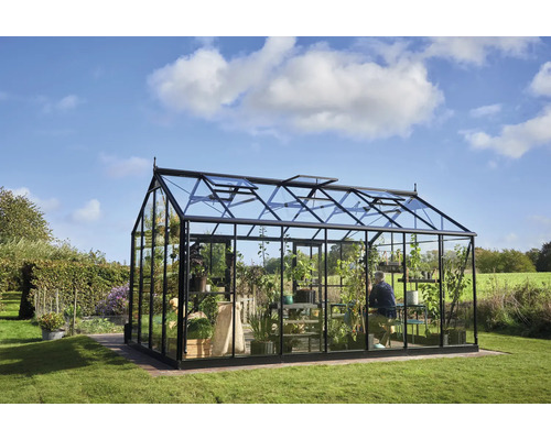 Serre avec plantes et personne dans le jardin