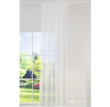 Panneau de rideau blanc devant une fenêtre avec vue sur le jardin