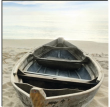 Ein hölzernes Ruderboot liegt am Strand.