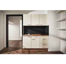Cuisine compacte avec évier, plaque de cuisson et espace de rangement dans une pièce lumineuse et moderne.