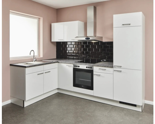 Cuisine claire avec évier, cuisinière, hotte aspirante et armoires de cuisine.