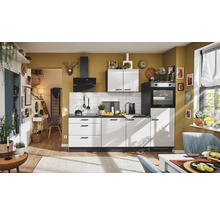 Cuisine lumineuse avec kitchenette, évier, cuisinière et hotte aspirante dans une pièce ensoleillée.