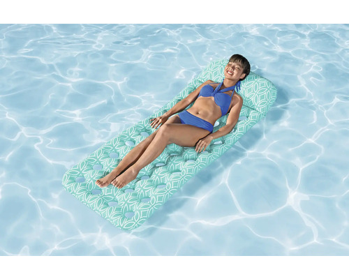 Frau entspannt auf einer Luftmatratze im Schwimmbad