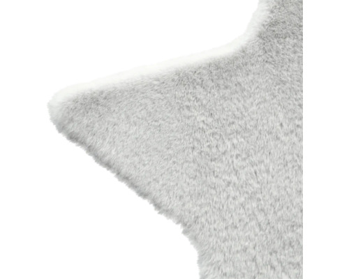 Detailaufnahme eines sternförmigen, hellen Teppichs mit weicher Textur