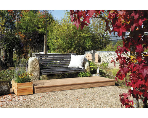 Gartenszene mit Holzterrasse, Steinbank und bepflanztem Blumenkasten