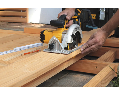 Eine Person schneidet Holz mit einer DeWalt Kreissäge.