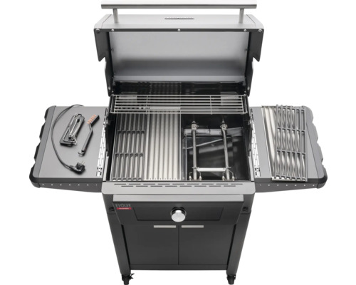 Barbecue à gaz ouvert avec grilles et accessoires sur une table d''appoint.