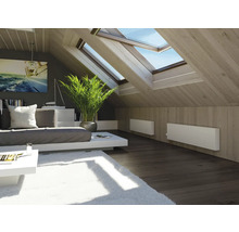 Chambre mansardée lumineuse avec fenêtres de toit, canapé, table, tapis et radiateurs
