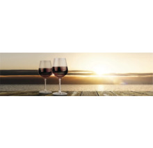 Deux verres à vin rouge sur une table en bois au coucher du soleil