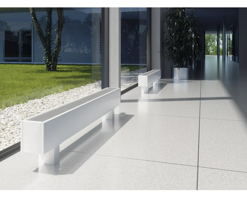 Scène avec deux radiateurs bancs blancs dans un espace au design moderne avec de grandes fenêtres et vue sur un jardin.