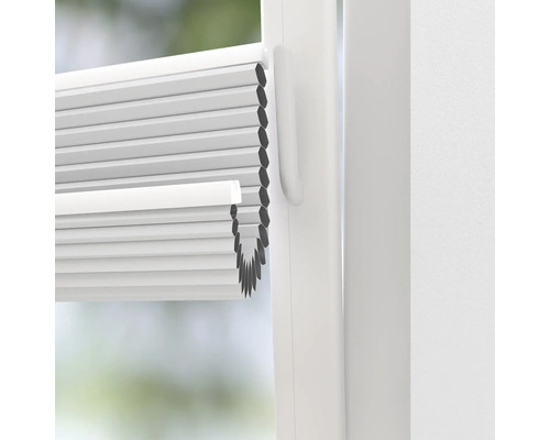 Gros plan d''un store plissé blanc sur la fenêtre