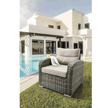 Fauteuil tressé avec coussins à côté de la piscine et de la maison