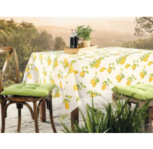 Table dressée avec une nappe à motif citron et des chaises à l''extérieur.