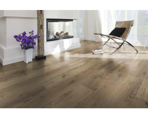 Pièce lumineuse avec parquet, cheminée et fauteuil