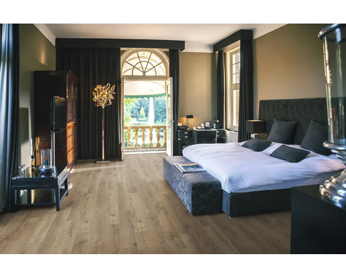 Chambre avec lit, armoire, lampadaire et balcon donnant sur un parc.