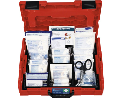 Geöffnete, rote Erste Hilfe Box mit diversen Verbandsmaterialien und einer Schere