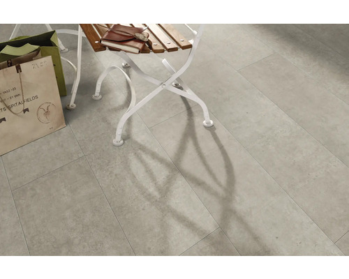 Verlegte Bodenfliesen im Innenbereich mit Schattenwurf eines Stuhls.