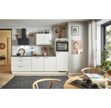 Cuisine claire avec armoires blanches, hotte aspirante et table à manger