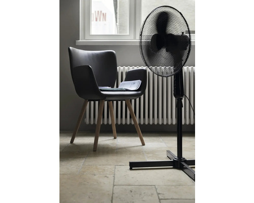 Vue d''une pièce avec une chaise noire, un ventilateur et un radiateur