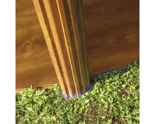 Detailansicht eines Gartenhauses mit Holzfassade und Fundament im Gartenbereich.