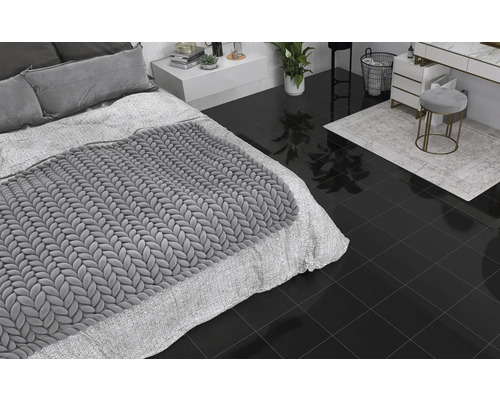 Chambre et salle de bains avec carrelage foncé, lit, commode et tabouret