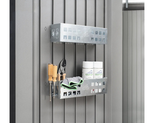 Zwei Regale aus Metall mit Werkzeugen, Reinigungstüchern und Spraydosen an einer Wand