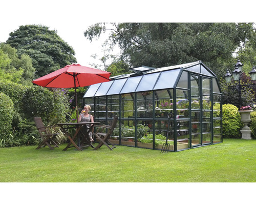 Serre de jardin avec plantes et outils de jardinage, à côté d''une table et de chaises sous un parasol