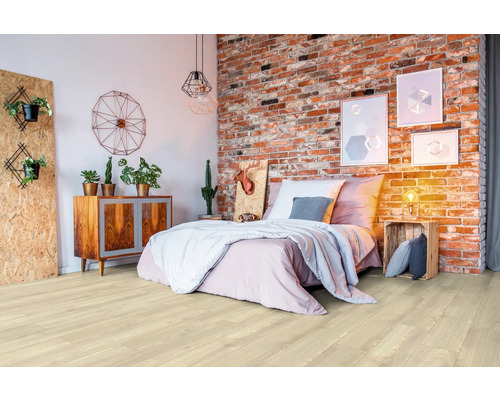 Heller Holzboden in einem Schlafzimmer mit Bett und Backsteinmauer