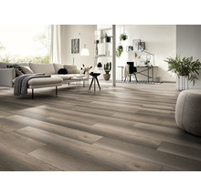 Salon lumineux avec parquet, canapé, table et espace de travail