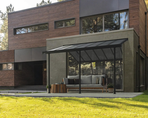 Überdachte Terrasse mit Sitzgruppe vor modernem Haus