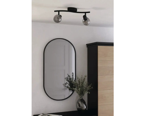 Plafonnier à deux lampes avec miroir ovale dans une pièce lumineuse