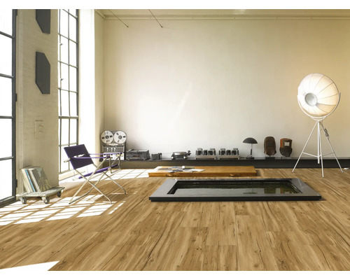 Pièce spacieuse avec sol en vinyle imitation bois, équipée d''un fauteuil, d''une lampe et d''une chaîne hi-fi