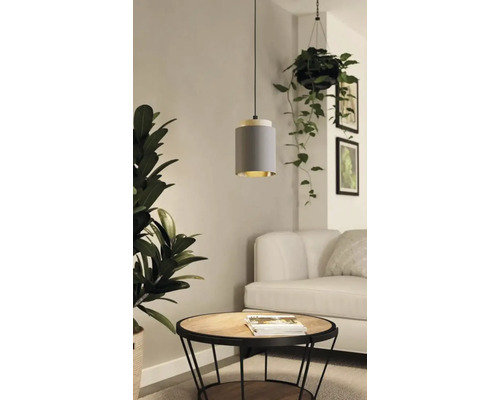 Lampe suspendue grise au-dessus d''une table ronde dans un salon.
