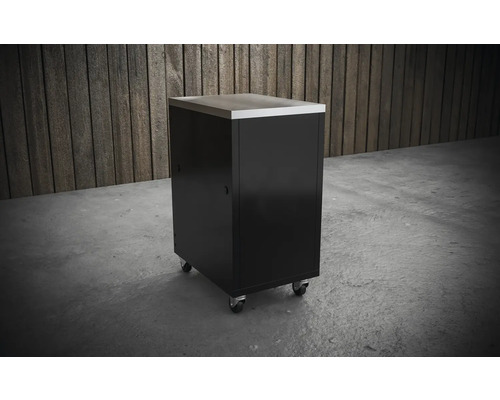 Rollbarer Werkstattschrank mit Edelstahlarbeitsplatte vor Holzwand