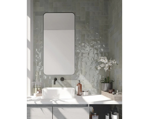 Badezimmer mit Waschtisch, Spiegel, Armatur und Wandfliesen