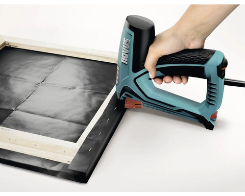 Eine Person verwendet einen elektrischen Tacker, um Leinwand auf einen Holzrahmen zu spannen. Novus Logo.