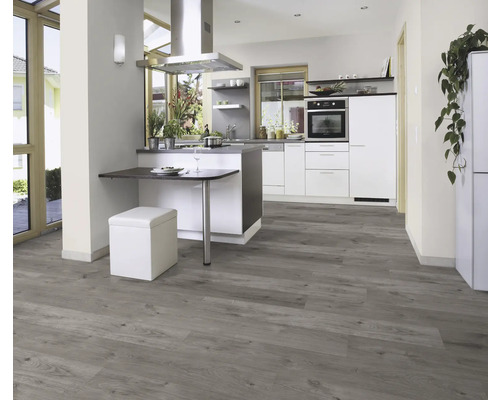 Helle Küche mit Küchenzeile, Esstisch und grauem Holzboden