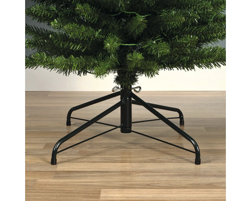Gros plan d'un sapin de Noël artificiel avec un support en métal noir