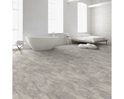 Heller Raum mit freistehender Badewanne, Bett und Bodenbelag in Marmoroptik