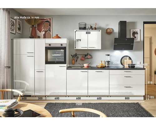 Cuisine complète avec armoires blanches, tiroirs, plan de travail, four et hotte.