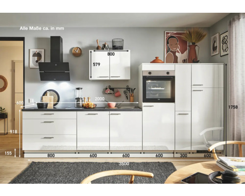 Komplette Küche mit weißen Fronten, Dunstabzugshaube und Elektrogeräten.